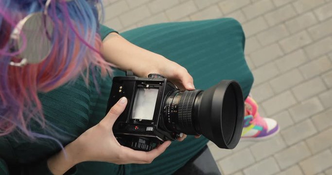 Old medium format camera in the hands of a hipster girl, close-up, film camera