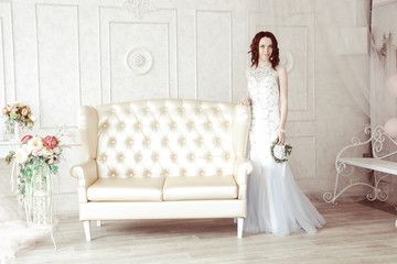 Fototapeta premium Beautiful young girl in evening dress posing at interior photo studio