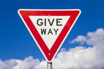 Give Way Sign Against A Blue Sky