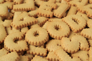 Close-up of the word GOOD spelled with alphabet shaped biscuits on the pile of same biscuits 