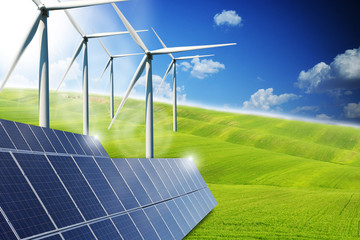 Renewable or green energy concept with solar panels and wind turbines on a green meadows
