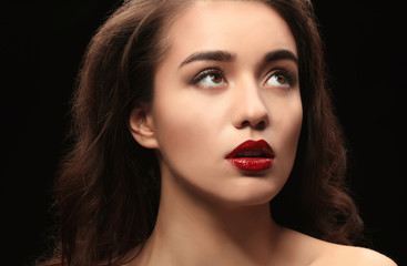 Fototapeta premium Portret pięknej kobiety z czerwonymi ustami na ciemnym tle
