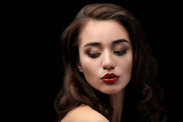 Fototapeta premium Portrait of beautiful woman with red lips on dark background