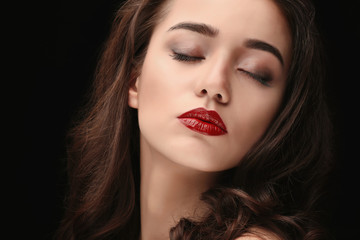 Fototapeta na wymiar Portrait of beautiful woman with red lips on dark background