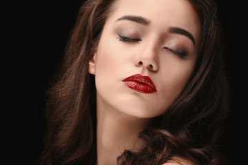 Portrait of beautiful woman with red lips on dark background