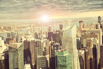 New York city skyline, sunrise in background.