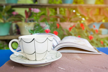 cup of coffee with book in the garden