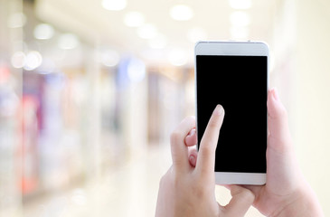 Hand using smart phone with blank screen over blur background, template, business and technology concept, digital marketing, seo, e-commerce, social media network, internet of things