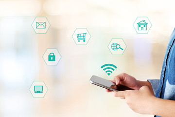 Hand using smart-phone with internet of things icon on blurred background, business and technology concept