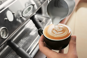 Man drawing on coffee with frothed milk