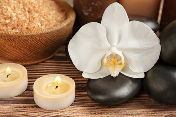Spa stones with flower on wooden table