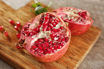 Half of fresh juicy pomegranate on wooden board, closeup