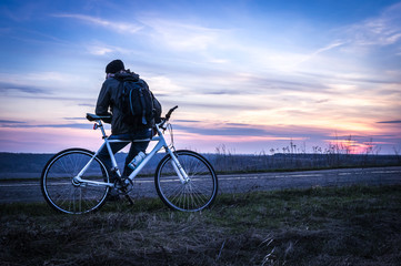 Naklejka na ściany i meble Man with bicycle at sunset