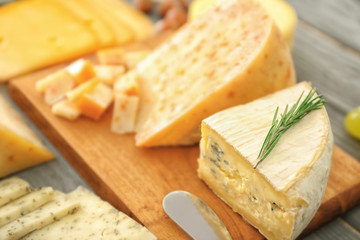 Assorted sliced cheese on wooden background