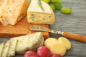 Assorted sliced cheese on wooden background
