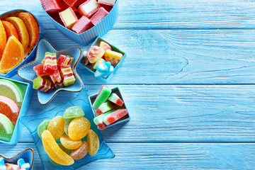 Composition with tasty jelly candies on wooden background
