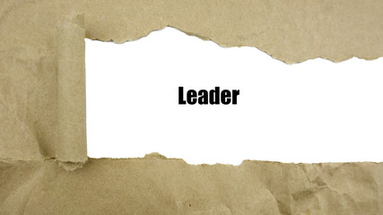 Torn brown paper on white surface with "Leader" word.