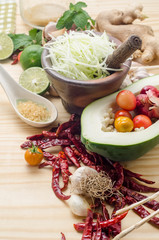 Ingredients for making papaya salad on a wooden table. Set of Thai spices and herbs
