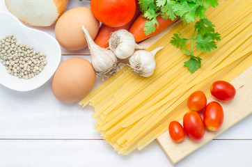 Pasta ingredients on white wooden background. Top view with copy space.
