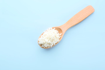 Wooden spoon with coconut rice on blue background
