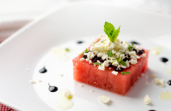 Fresh watermelon salad starter. This watermelon cubes salad is made with greek feta cheese crumbs, olive slices, mint, olive oil and balsamic vinegar. So refreshing, the perfect food for the summer!