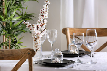 Beautiful festive table setting and flower decor in light room