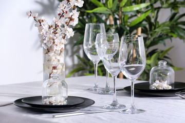 Beautiful festive table setting and flower decor in light room