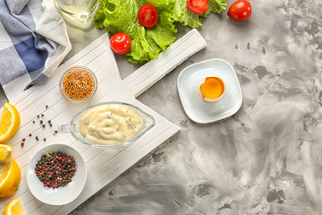 Delicious mayonnaise in gravy boat with ingredients on kitchen table, top view