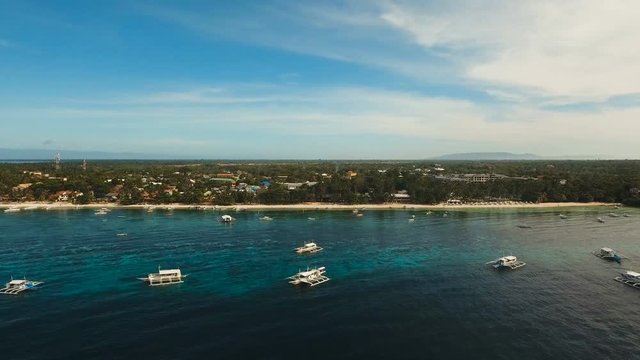 Aerial view of tropica Alona beach on the island Bohol, resort, hotels, Philippines. Beautiful tropical island with sand beach, palm trees. Tropical landscape. Seascape: Ocean, sky, sea. 4K video