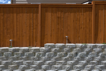 Wood Fencing on Cement Stack Stone Retaining Wall