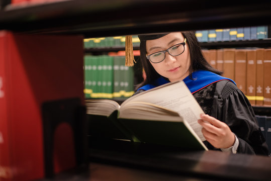 PhD Student Reading A Book In Library