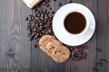 Coffee cup and coffee beans on wooden background