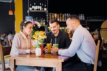 Friends drinking coctails in a cafe.