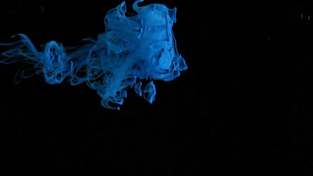 Cloud of ink floating slowly trough space, close up, black background