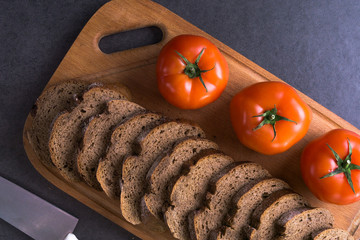 fresh tomatoes with homemade bread, lying on the wooden Board