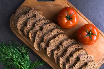 fresh tomatoes with homemade bread and greens, lie on the wooden Board