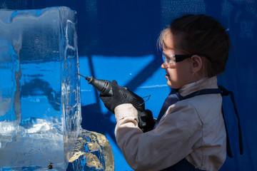 Girl of seven years in the master class on ice sculpture