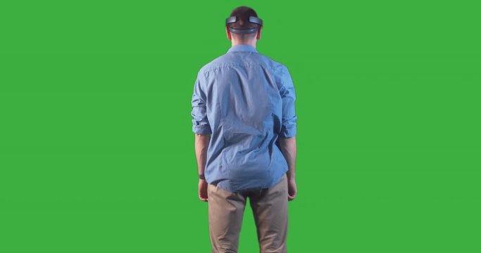 Young adult Caucasian male using holographic augmented reality glasses. Green screen chroma key. Left side key light. 4K UHD RAW edited footage