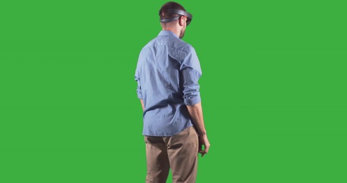 Young adult Caucasian male using holographic augmented reality glasses. Green screen chroma key. 4K UHD RAW edited footage