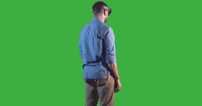 Young adult Caucasian male using holographic augmented reality glasses. Green screen chroma key. Right side key light. 4K UHD RAW edited footage