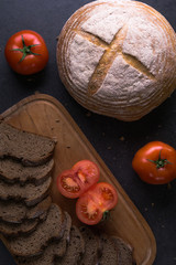 fresh tomatoes with homemade bread, lying on the wooden Board