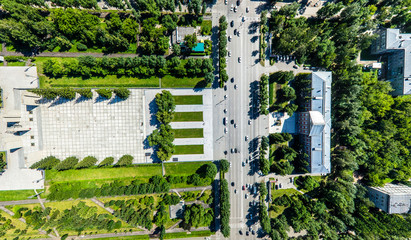 Aerial city view with crossroads, roads, houses, buildings, parks and parking lots. Copter drone helicopter shot. Panoramic wide angle image.