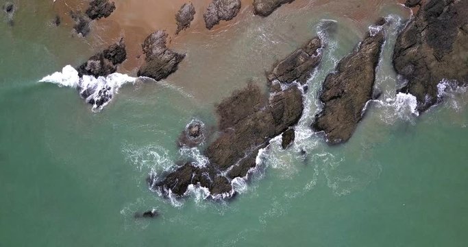 Aerial footage of waves and rock reef with turquoise sea water. Summer nature bird eye view.
