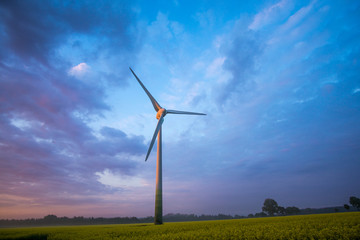 wind wheels at sunrise and fog with dark clouds