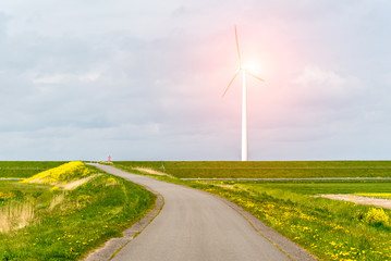 Sunset above the windmill close to the road