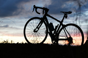 Fototapeta na wymiar bicycle silhouette on sunset in Summer 