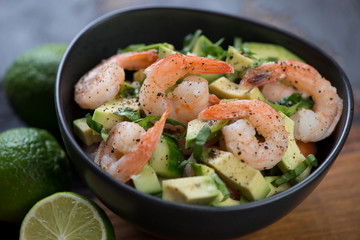 Avocado salad with tiger shrimps and cucumber, selective focus, close-up, studio shot