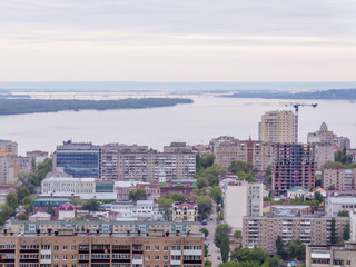 The city's skyline. The Russian province of Saratov. High-rise residential buildings, the Volga river and the railway bridge on the horizon