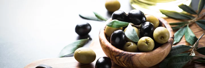 Fototapeten Black and green olives in wooden bowl © nadianb