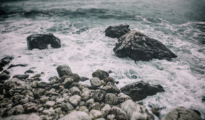 Wave and stone shore close-up. Beautiful abstract natural background and texture